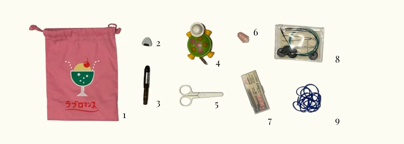 1. Hightide drawstring bag. 2. The Knitting Box onigiri magnetic cord stopper. 3. PENCO bullet pencil light. 4. Wiggle Wiggle measuring tape. 5. MUJI small scissors. 6. rubber finger tips. 7. interchangable needles , stitch markers, and darning needle in MUJI case. 8. more cables and stoppers in MUJI pouch. 9. stitch holder.